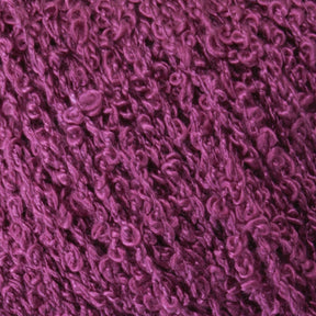 A close-up image of textured, purple yarn with a boucle pattern, perfect for knitting and weaving. The yarn appears soft and slightly fuzzy, with tiny loops and twists creating a rich, tactile surface. Named Gemstone Silk Bouclé by Halcyon Yarn, the deep shade of purple resembles luxurious silk yarn in its richness.