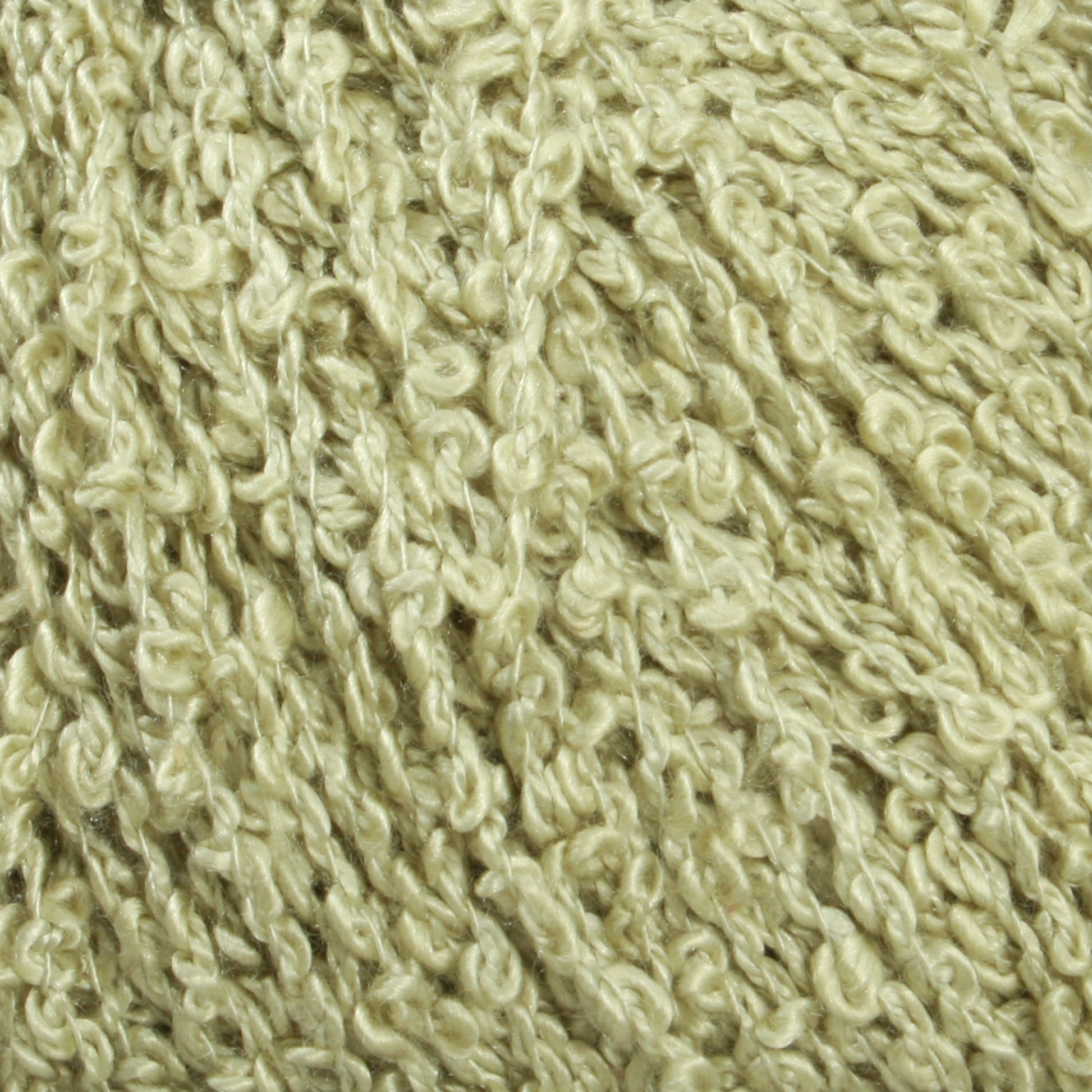 Close-up image of Halcyon Yarn's Gemstone Silk Bouclé in a light beige color. The textured yarn exhibits a curly and irregular pattern, giving it a soft and bumpy appearance. The image emphasizes the intertwined strands and intricate details of the fiber.