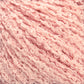 Close-up image of soft, pale pink *Gemstone Silk Bouclé* yarn by *Halcyon Yarn* with a textured, loopy, and curly appearance. The fibers are arranged in a dense, intertwined pattern, giving the yarn a cozy and fluffy look.