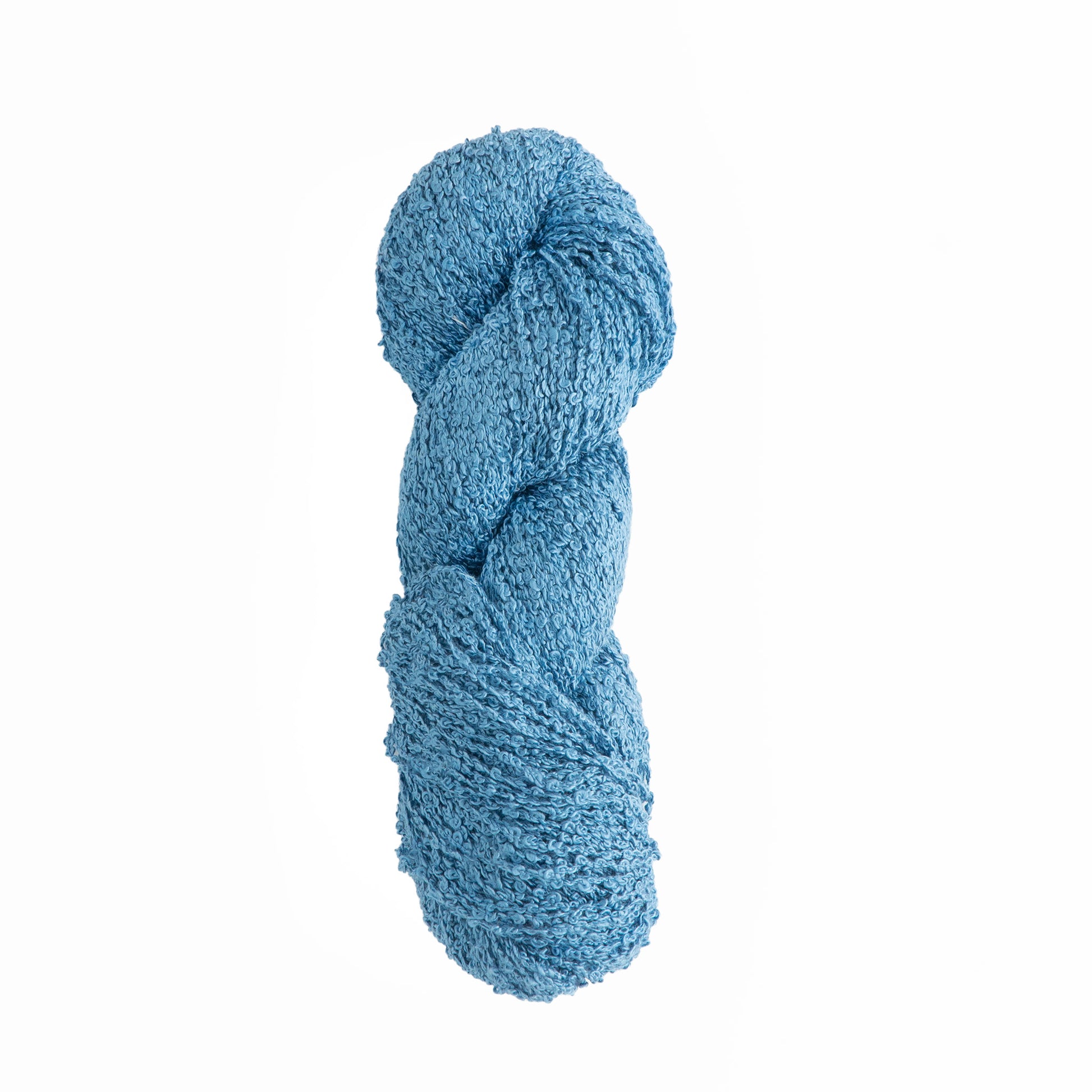 A twisted skein of textured blue yarn is displayed against a plain white background. The yarn has a slightly bumpy surface, indicating it is a boucle type, suitable for knitting or crocheting projects that require a softer, more tactile fabric. This Gemstone Silk Bouclé from Halcyon Yarn promises luxury in every stitch.