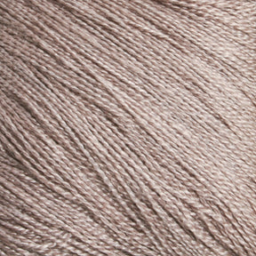 A close-up view of the soft, fine texture of Halcyon Yarn's Gemstone Silk 2/30 in light brown, showcasing its tightly spun strands. The smooth and slightly reflective surface indicates the luxurious quality of this silky yarn.