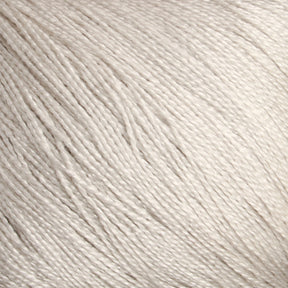 Close-up image of Halcyon Yarn's Gemstone Silk 2/30, showcasing its soft, creamy white fibers with a smooth, slightly shiny texture. The yarn's neatly aligned threads display fine details and subtle variations in thickness, reminiscent of lace-weight silks, creating a sense of depth and intricate detail.