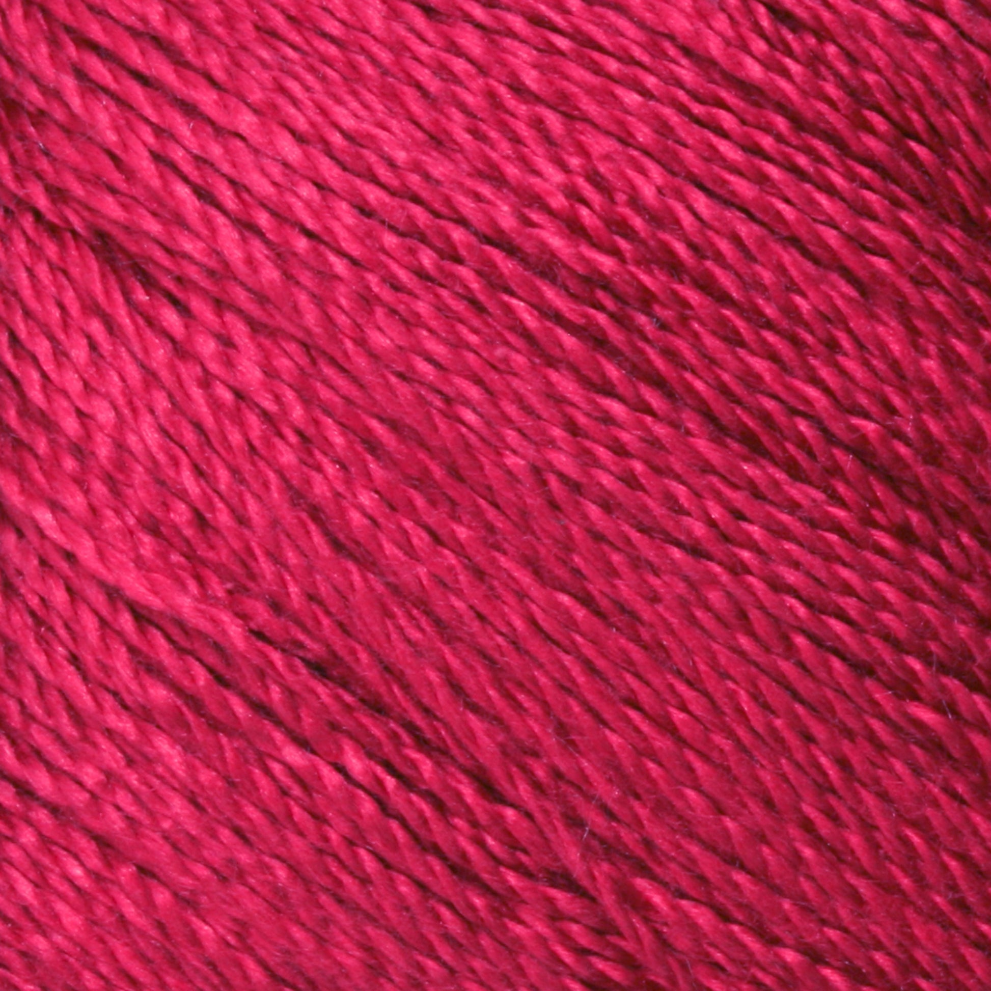 Close-up of a vibrant, rich red Gemstone Silk 2/12 yarn by Halcyon Yarn. The texture of the yarn is smooth and slightly shiny, with individual strands and fibers clearly visible. The color is uniform throughout the image, highlighting the intricacies of the woven threads, reminiscent of luxurious gemstone silks.