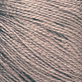 A close-up image of tightly wound Gemstone Silk 2/12 yarn in a beige hue from Halcyon Yarn. The twisted strands create a textured appearance with a slight sheen under the light, highlighting the detailed and intricate composition of the fibers, making it ideal for weaving or knitting luxurious projects.