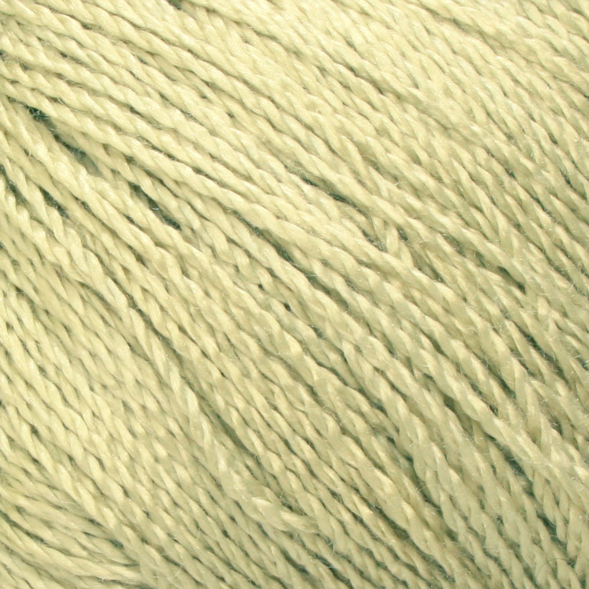 Close-up image of a ball of Gemstone Silk 2/12 yarn by Halcyon Yarn. The strands are tightly twisted together, creating a textured and detailed pattern. The soft light yellow color and fibrous material convey a sense of warmth and softness, perfect for knitting cozy garments.