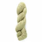 A skein of Halcyon Yarn's Gemstone Silk 2/12 in a light green hue is neatly twisted into a long coil. The texture appears soft and smooth, perfect for knitting or crocheting projects. The plain white background ensures that the luxurious yarn remains the focal point of the image.