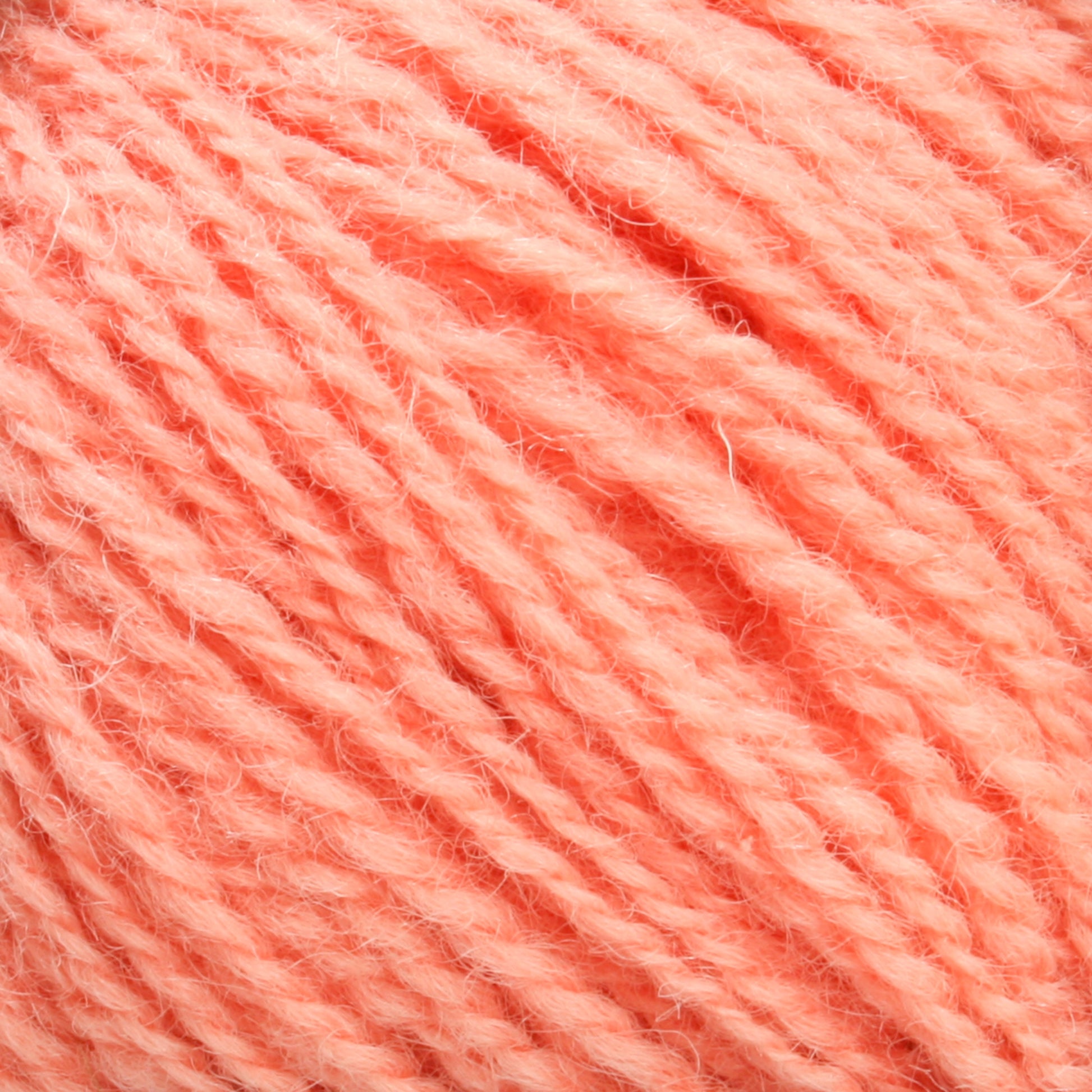 Close-up image of a coral-colored Victorian 2-Ply Wool Yarn perfect for hand knitting. The texture shows several strands twisted together, highlighting its fibrous and soft appearance of this sport weight yarn from Halcyon Yarn.