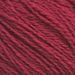 Close-up of Halcyon Yarn's Victorian 2-Ply Wool Yarn, showcasing the soft, fibrous texture and twisted strands. The sport weight wool appears thick and slightly fuzzy, with a rich, deep red color perfect for hand knitting.