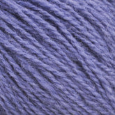 Close-up image of Halcyon Yarn's Victorian 2-Ply Wool Yarn in a soft, textured sport weight with a rich lavender hue. The wool fibers appear loosely spun, giving a slightly fuzzy look, ideal for hand knitting or crocheting projects. The lighting accentuates the different shades of purple within the strands.