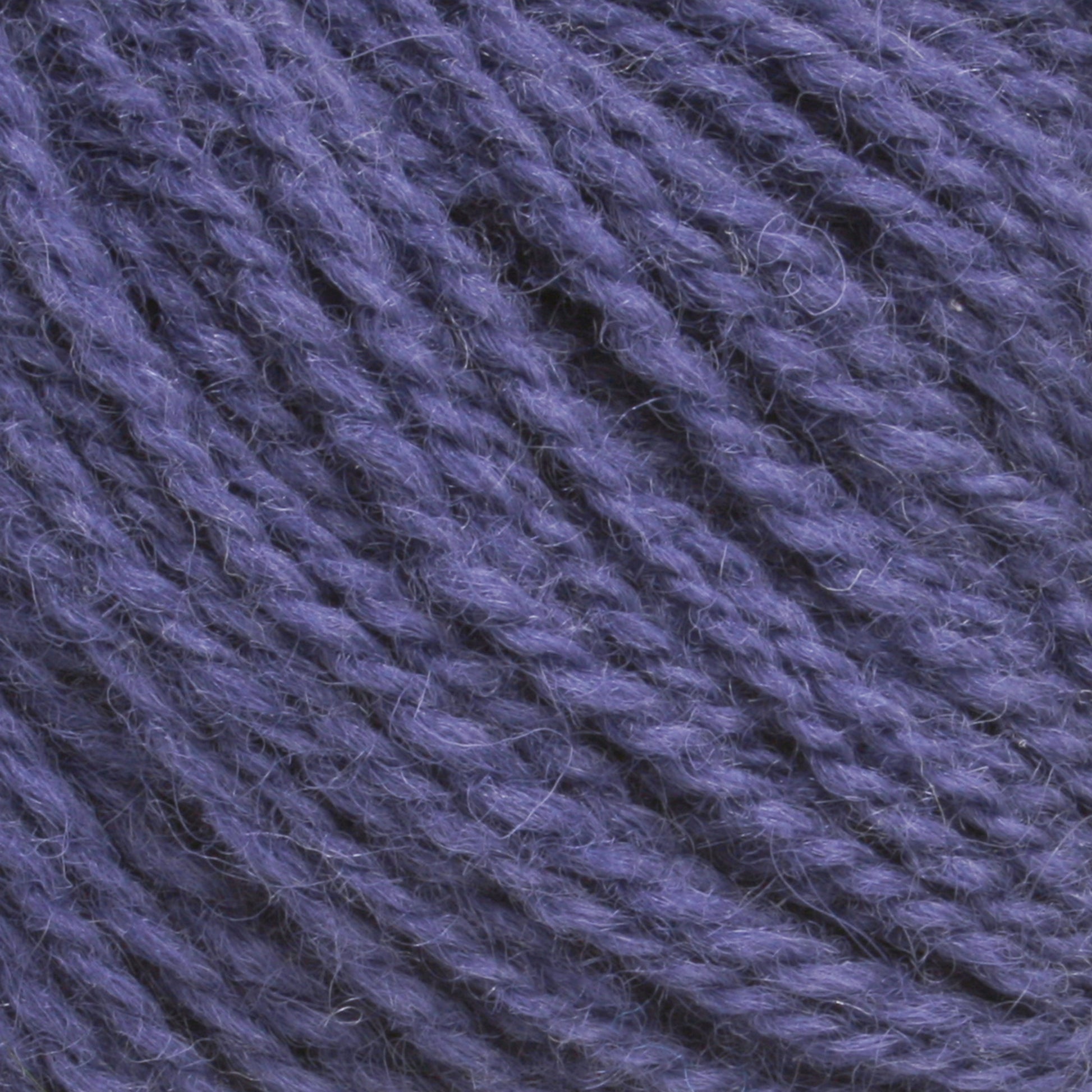 Close-up of a ball of Victorian 2-Ply Wool Yarn from Halcyon Yarn, showing the texture and interwoven strands. The sport weight yarn appears soft and slightly fuzzy, with a tight twist and consistent thickness throughout—perfect for hand knitting projects.