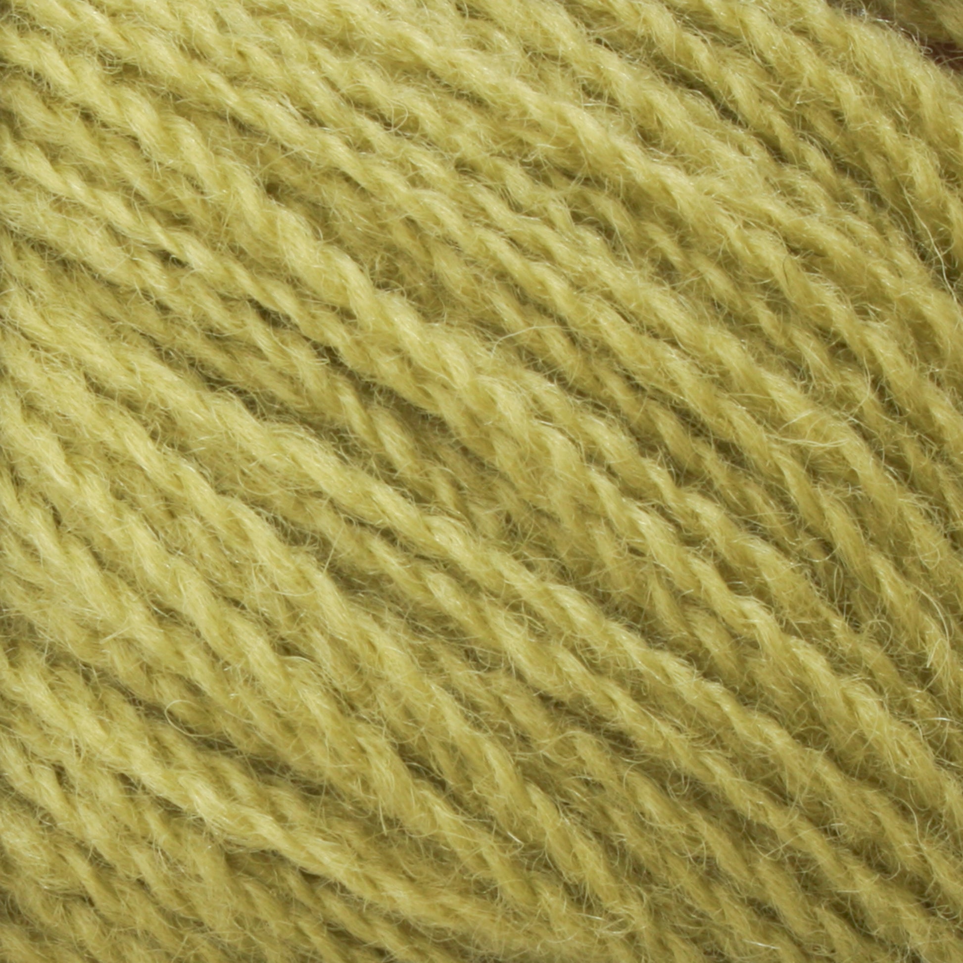 Close-up image of strands of Halcyon Yarn's Victorian 2-Ply Wool Yarn in a vivid yellow sport weight, tightly wound together to showcase the texture and fibers of the material. The yarn appears soft and slightly fuzzy, making it perfect for hand knitting projects.