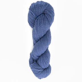 A skein of Halcyon Yarn's Victorian 2-Ply Wool Yarn is coiled neatly against a white background. The yarn appears soft and slightly textured, suitable for knitting or crocheting projects. The color is a rich, medium blue. Perfect for creating intricate multi-color sweater designs.