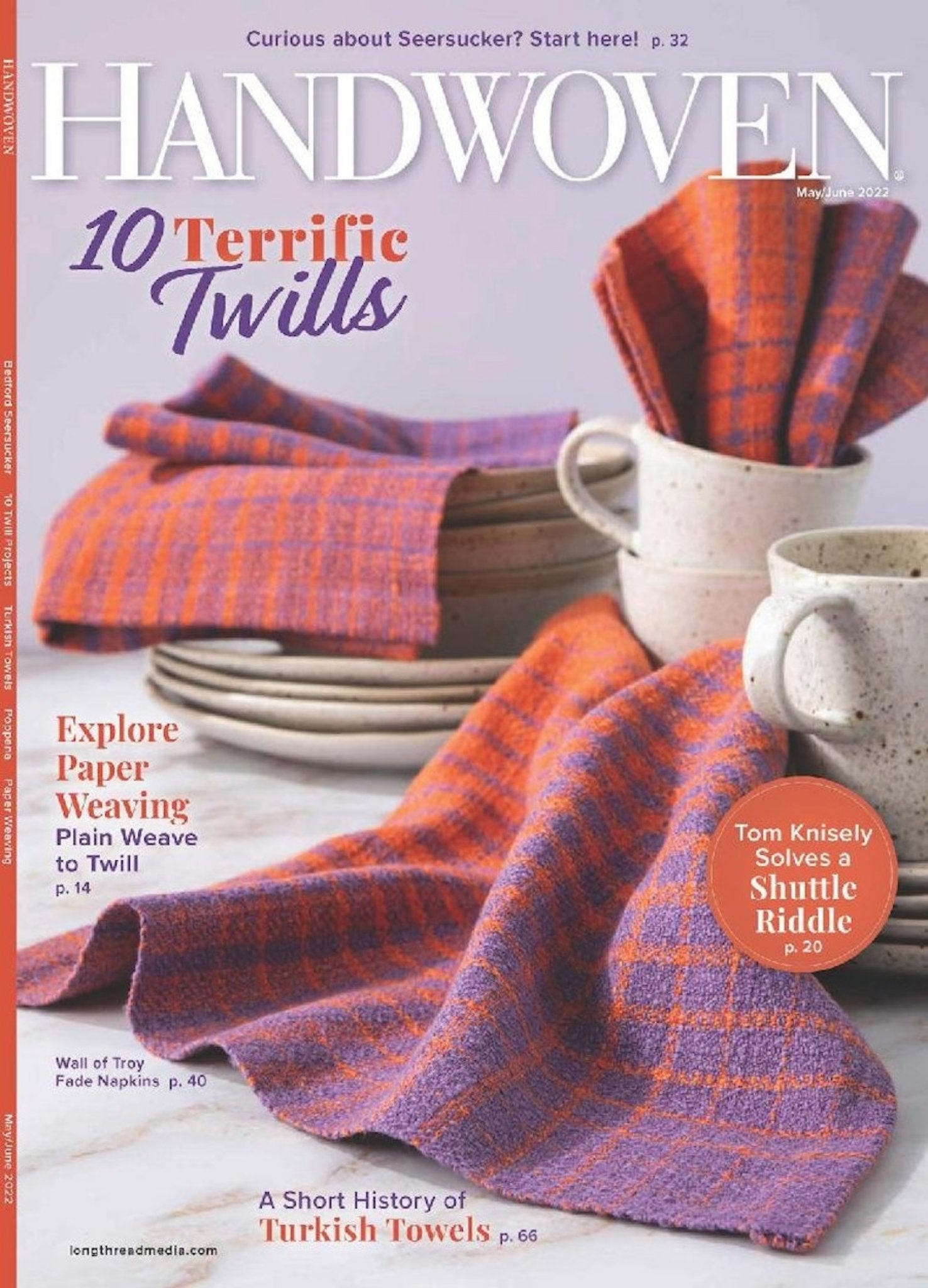 The cover of Long Thread Media's Handwoven Magazine May/June 2022 issue showcases orange and purple twill napkins along with a fabric swatch. The headline reads "10 Terrific Twills," highlighting articles on paper weaving, Turkish towels, and shuttle riddles.