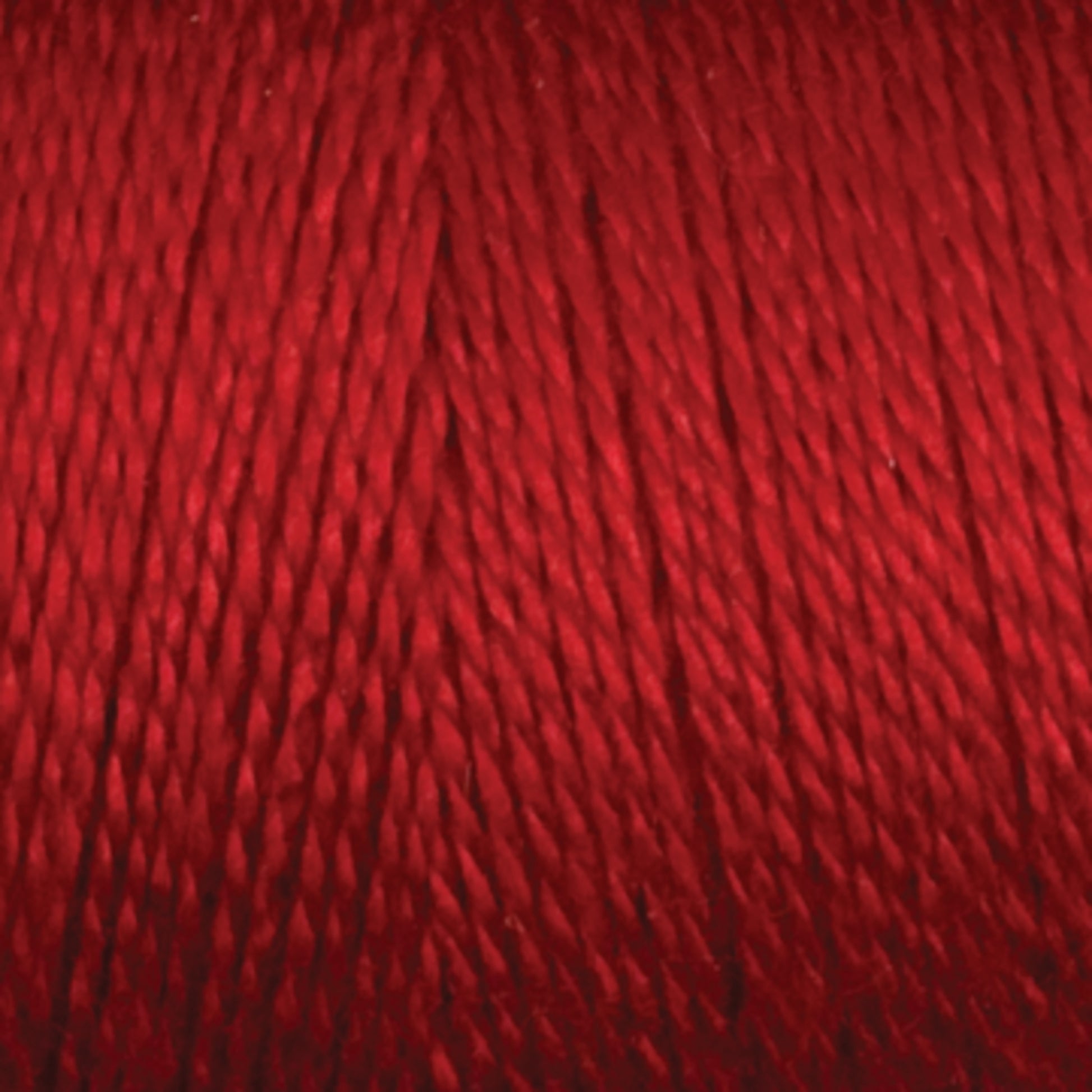 Close-up image of a spool of Maurice Brassard 8/2 Tencel Yarn | Tube in red, showing the tightly wound strands. Ideal for weaving projects, the texture and vibrant color of this Tencel yarn are clearly visible.