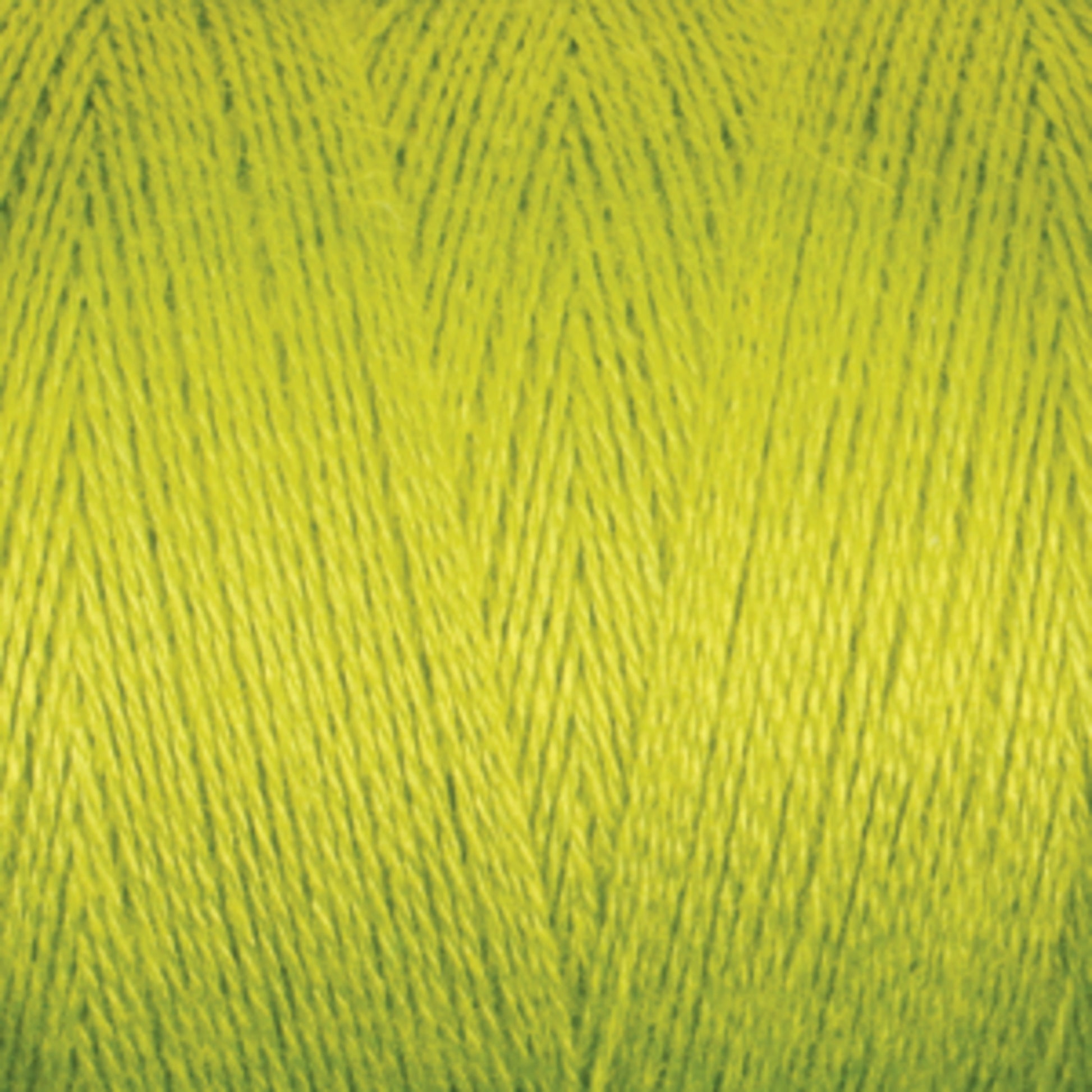 Close-up of a spool of bright yellow-green Maurice Brassard 8/2 Tencel Yarn. The tightly wound fibers create a textured, crisscross pattern, showcasing the yarn's smooth and glossy finish. Perfect for knitting accessories or weaving projects, its vibrant color makes a bold and lively impression.