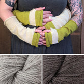 Close-up of two people wearing color-blocked fingerless mitts in green and beige, embracing each other. Below, there are two skeins of Herriot Fine alpaca yarn—one in light grey and the other in dark brown—from the Whole Wide World Fingerless Mitts Kit by Halcyon Yarn, perfect for this advanced beginner knitting project.