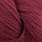 A close-up image of soft, deep red yarn fibers. The texture appears slightly fuzzy, with individual strands visible. Made from Baby alpaca, the Herriot Fine Alpaca by Juniper Moon Farm yarn is tightly wound, creating a cozy and warm appearance ideal for knitting sumptuous socks. This premium product is offered by Knitting Fever / Euro.