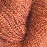 Close-up of a skein of Herriot Fine Alpaca by Juniper Moon Farm, offered by Knitting Fever/Euro, in a rich, reddish-brown color. The fibers show slight variations in shade, adding depth and texture to the appearance of the yarn, perfect for creating lightweight accessories.