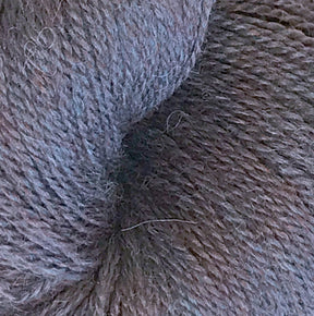 Close-up image of a skein of Herriot Fine Alpaca by Juniper Moon Farm from Knitting Fever / Euro, showcasing its soft, multi-toned gray texture. The dense and slightly fluffy fibers suggest it's made from baby alpaca, making it ideal for creating cozy, warm materials suitable for knitting or crocheting lightweight accessories.