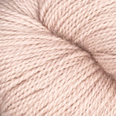 Close-up image of a skein of Herriot Fine Alpaca by Juniper Moon Farm yarn in soft, light pink. The individual strands are tightly twisted together, creating a smooth, even texture. This luxurious yarn from Knitting Fever / Euro is perfect for knitting or crocheting sumptuous socks and lightweight accessories.