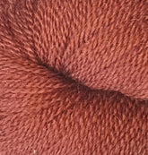 Close-up of a skein of Herriot Fine Alpaca by Juniper Moon Farm from Knitting Fever / Euro, showcasing its tightly woven fibers and soft texture. The reddish-brown yarn appears to be thickly twisted, indicating a durable and cozy material suitable for knitting sumptuous socks or lightweight accessories.