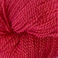 Close-up view of Herriot Fine Alpaca by Juniper Moon Farm yarn, showing detailed texture and tightly wound strands. The vibrant red fibers are densely packed, with visible twists and loops, indicating a soft yet durable material perfect for knitting sumptuous socks or lightweight accessories. Brought to you by Knitting Fever / Euro.