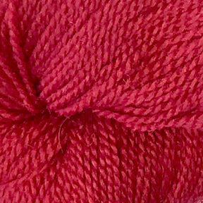 Close-up view of Herriot Fine Alpaca by Juniper Moon Farm yarn, showing detailed texture and tightly wound strands. The vibrant red fibers are densely packed, with visible twists and loops, indicating a soft yet durable material perfect for knitting sumptuous socks or lightweight accessories. Brought to you by Knitting Fever / Euro.