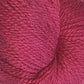 Close-up of a ball of Herriot Fine Alpaca by Juniper Moon Farm yarn in light red, showcasing the texture and fibers. Made from Baby alpaca, this Knitting Fever / Euro yarn appears soft and slightly fuzzy, suitable for knitting sumptuous socks or lightweight accessories.