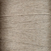 Close-up view of tightly wound beige Newport 16/2 Linen Yarn, showing the texture and fine fibrous strands. The yarn appears slightly rough, with varying thickness and a natural, rustic appearance reminiscent of woven items from Halcyon Yarn's collection.