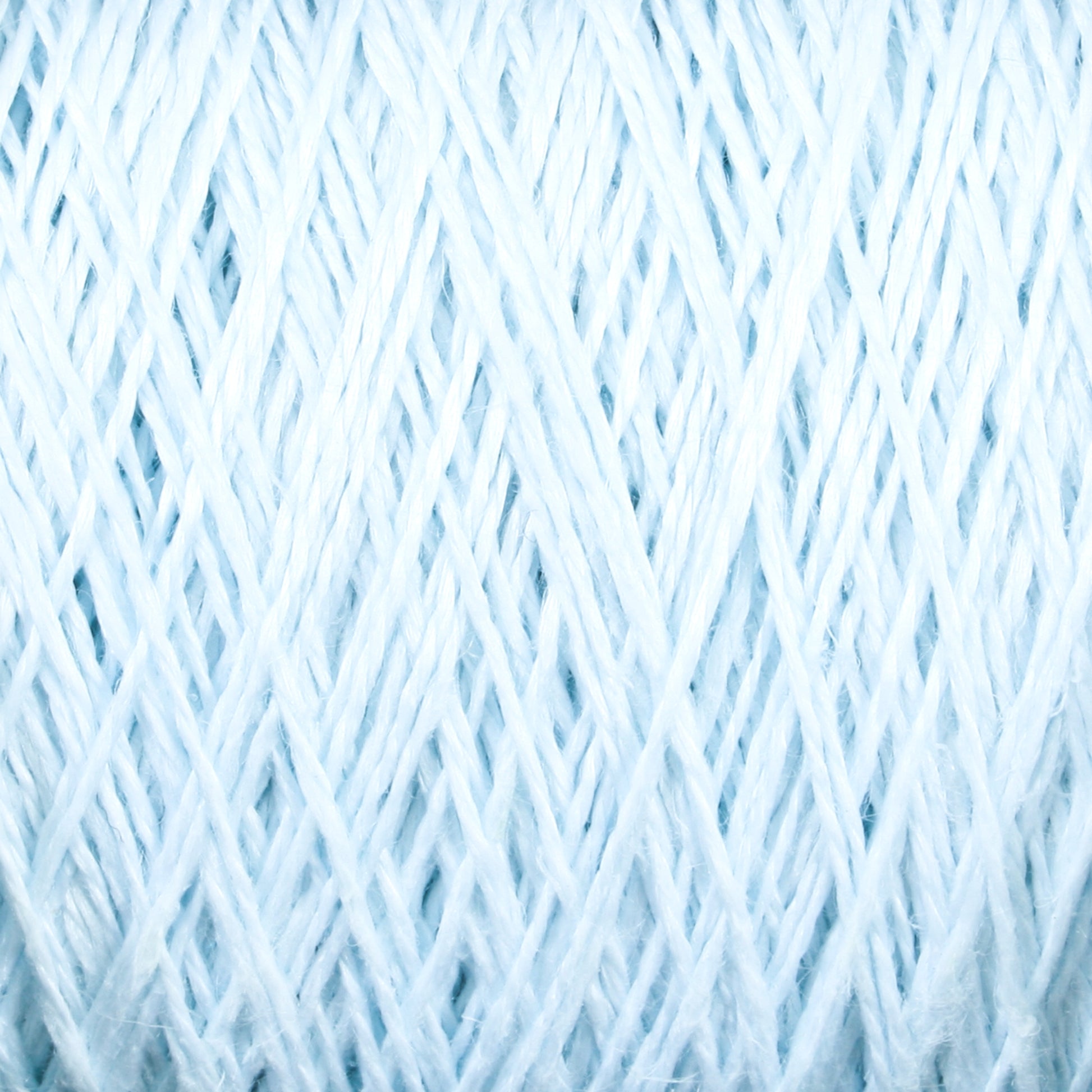 Close-up image of the light blue Newport 16/2 Linen Yarn from Halcyon Yarn, showcasing tightly woven threads arranged in a crisscross pattern. The texture appears soft and delicate, highlighting the intricate details of the fibers on this large cone of yarn.