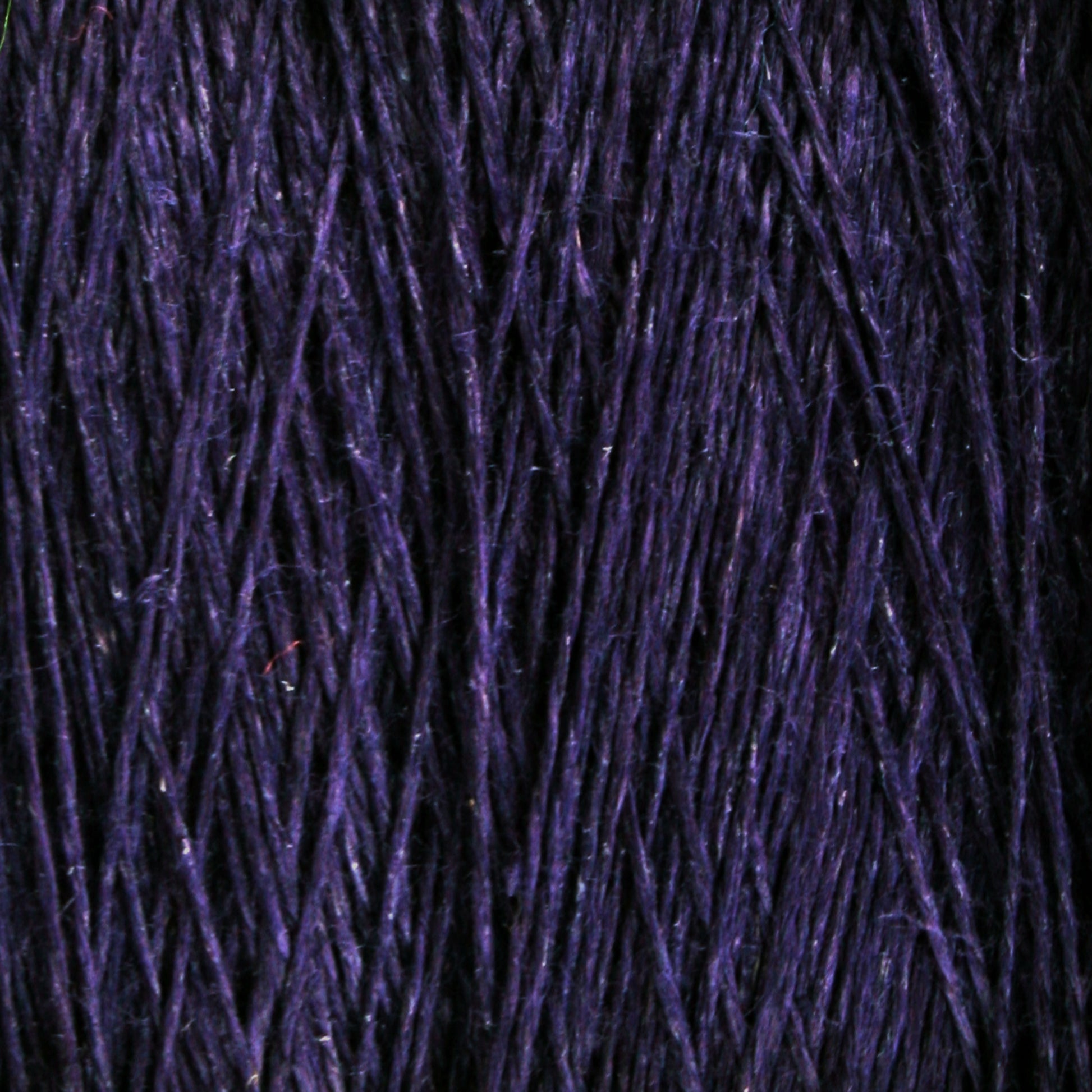 Close-up image of Halcyon Yarn's Newport 16/2 Linen Yarn | Mini-cone strands in deep purple, showcasing their rich color and detailed texture. The linen yarn appears smooth and soft, with subtle variations in shading that add depth to its overall appearance.