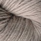 Close-up image of soft, light grey Moonshine by Juniper Moon Farm yarn. The tightly wound fibers create a spiral pattern, showcasing the alpaca yarn's smooth texture and slight fuzziness. The soft, neutral color is consistent throughout, making this Knitting Fever / Euro yarn appear cozy and inviting.