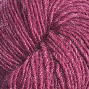 Close-up image of a skein of Moonshine by Juniper Moon Farm alpaca yarn in a deep red hue, slightly fuzzy. The fibers are tightly twisted together, showcasing the texture and richness of the color. This yarn from Knitting Fever / Euro appears soft and is perfect for knitting or crocheting projects.