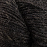 Close-up image of thick strands of dark brown Moonshine by Juniper Moon Farm yarn from Knitting Fever / Euro, showcasing its texture and slight variations in color. The yarn appears soft and slightly fuzzy, with a few stray fibers visible.