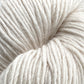 A close-up of a skein of Moonshine by Juniper Moon Farm, coiled tightly and showcasing its thick, off-white texture. The soft and slightly fuzzy yarn reveals individual strands with a subtle sheen, highlighting the high-quality wool fiber from Knitting Fever / Euro.