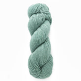 A skein of Moonshine by Juniper Moon Farm yarn, a luxurious wool alpaca silk blend from Knitting Fever / Euro, is tightly wound into a neat, elongated shape against a plain white background. The texture of this worsted-weight light teal yarn appears soft and slightly fuzzy, perfect for knitting or crocheting exquisite garments.