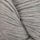 Close-up image of a soft, thick skein of light gray Juniper Moon Farm Herriot Baby Alpaca yarn with slight variations in color. The fibers from Knitting Fever / Euro are slightly fuzzy, giving a cozy texture and appearance.