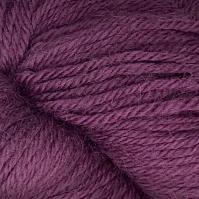 Close-up of a skein of dark purple Juniper Moon Farm Herriot Baby Alpaca yarn from Knitting Fever / Euro. The yarn has a smooth texture with visible individual threads, showcasing its rich and vibrant color. Crafted from extrafine baby alpaca, this DK weight yarn is perfect for luxurious knitting projects.