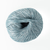 A ball of light blue Katia Air Lux yarn from Knitting Fever / Euro, featuring a soft, slightly shiny texture. The fingering weight yarn is neatly wound and sits against a plain white background, highlighting its color and fibers.