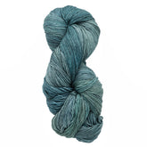 A skein of Malabrigo Sock by Malabrigo Yarn, featuring kettle-dyed teal with varied shades, tightly wound and textured, set against a white background.