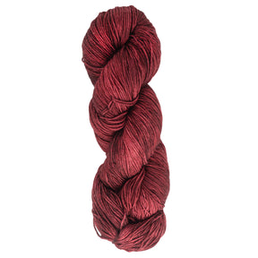 A skein of Malabrigo Sock made by Malabrigo Yarn, featuring deep red, kettle-dyed superwash merino wool with a tight twist that highlights subtle color variations against a white background.