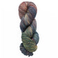 The Malabrigo Sock, a versatile yarn by Malabrigo Yarn, is crafted from superwash merino wool and showcases a stunning gradient of colors with shades of blue, green, and red, neatly coiled against a plain white background.