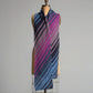 A long, knitted Diagonal Scarf with diagonal stripes in various shades of pink, purple, blue, and gray draped over a dress form against a plain background. Crafted with Superfine 400 Alpaca Braids by Yarn & Soul, the scarf appears soft and cozy, showcasing a gradient pattern. Enjoy this limited offer with a free pattern from Yarn & Soul!