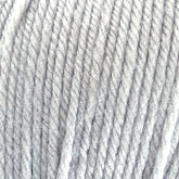 Close-up view of a soft, light grey yarn made from 100% Cascade Yarns' Cascade 220 Superwash Wool Yarn. The image shows the DK weight yarn's texture in detail, with clearly visible fibers and twists. The overall appearance is fluffy and slightly fuzzy, highlighting the fine threads and beautiful stitch definition.