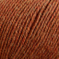 Close-up view of Cascade 220 Superwash Wool Yarn, showing tightly wound strands in various shades of warm brown and orange with a slightly rough and textured appearance. The fiber, made from 100% merino wool by Cascade Yarns, looks natural and wool-like, with a mix of fine and coarse threads.