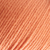 Close-up image of Cascade 220 Superwash Wool Yarn in orange, revealing its tightly twisted fibers and soft texture. The strands of this DK weight yarn by Cascade Yarns run diagonally across the image, showcasing beautiful stitch definition.