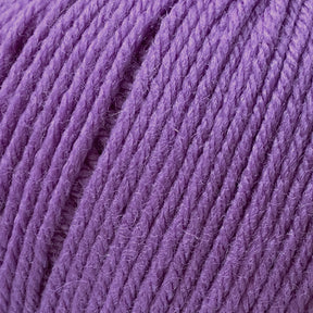 Close-up view of Cascade 220 Superwash Wool Yarn by Cascade Yarns in a vibrant purple shade, showcasing its tightly wound strands with a slightly fuzzy texture, perfect for knitting or crocheting projects. The image highlights the rich color and fine detail of this 100% merino DK weight wool yarn's fibers, promising beautiful stitch definition.