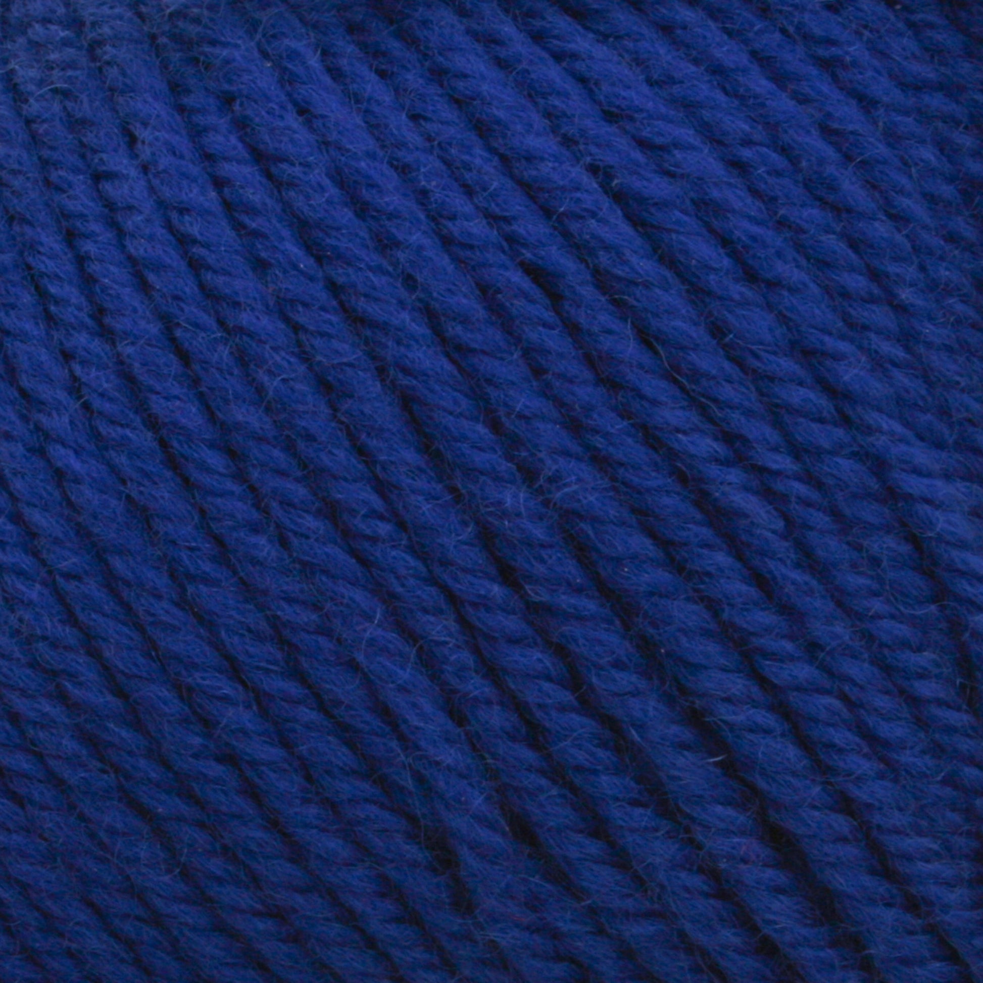 Close-up image of Cascade 220 Superwash Wool Yarn by Cascade Yarns in deep blue, wound into a ball. The 100% merino wool strands are tightly woven together, creating a textured, fibrous surface that boasts beautiful stitch definition.