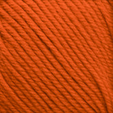 Close-up of Cascade 220 Superwash Wool Yarn in orange, showcasing tightly wound strands. The 100% merino wool texture from Cascade Yarns appears soft, with visible twists in the fiber, offering beautiful stitch definition. Suitable for knitting or crocheting projects.