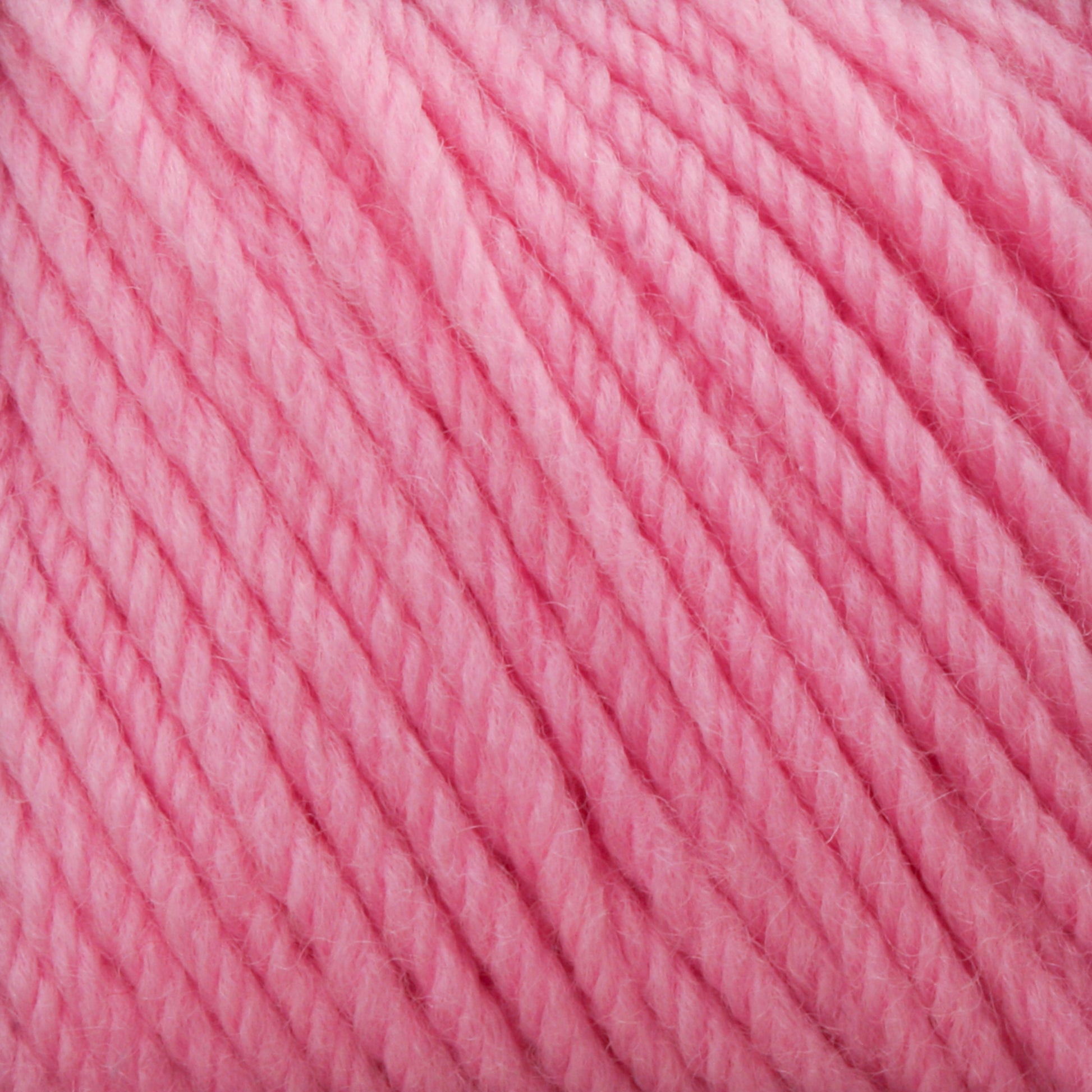 A close-up image of Cascade 220 Superwash Wool Yarn fibers in a vibrant pink hue reveals the texture of the DK weight, 100% merino wool. The soft, twisted strands are tightly knit, showcasing excellent stitch definition and creating a cozy, warm appearance.